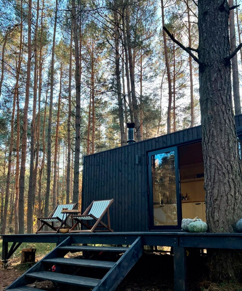 darkened plywood coats REDUKT's mobile tiny cabin offering an off-grid retreat